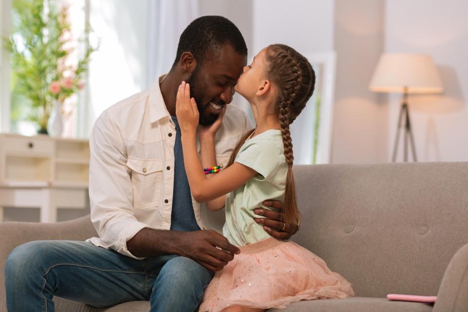 Father and daughter play together in the living room.