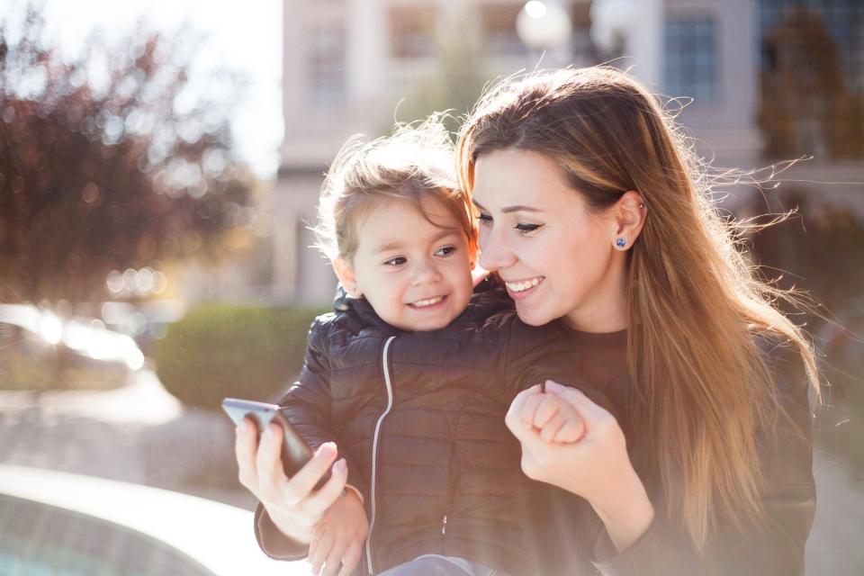 Mother and daughter spend a fall afternoon together outside.