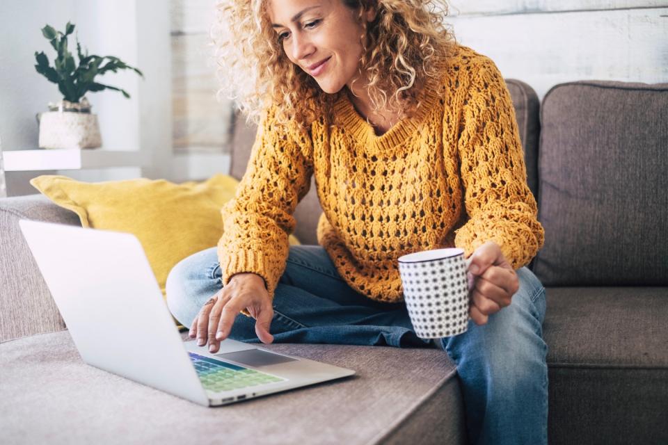 Woman does research on her computer from her living room.