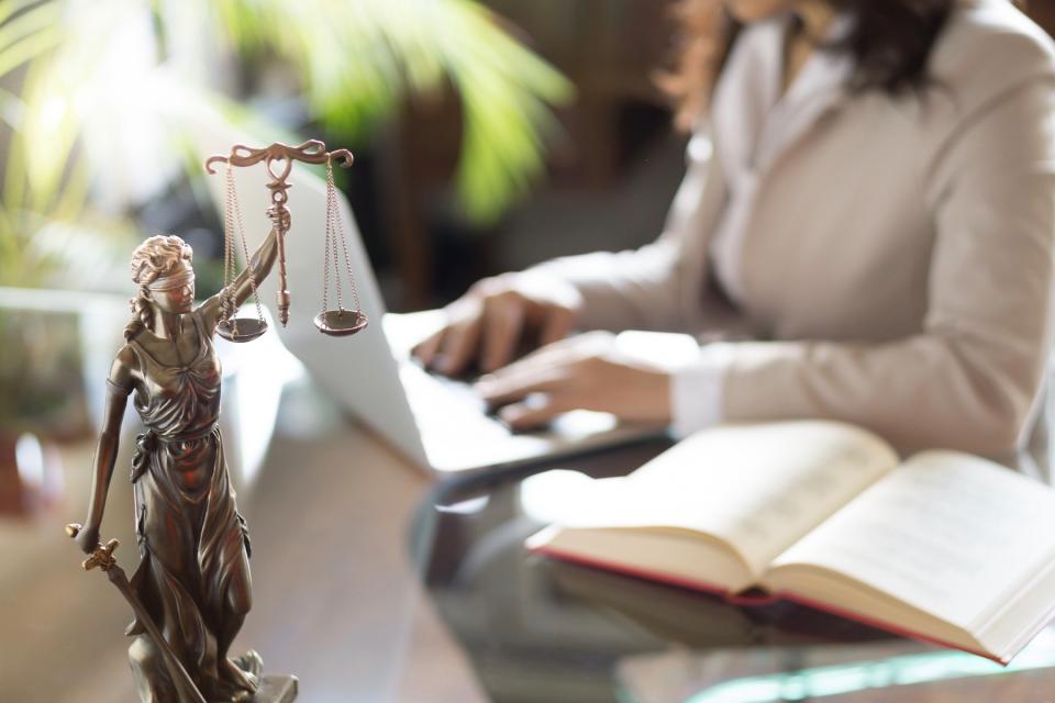 An attorney works on her computer at her desk.