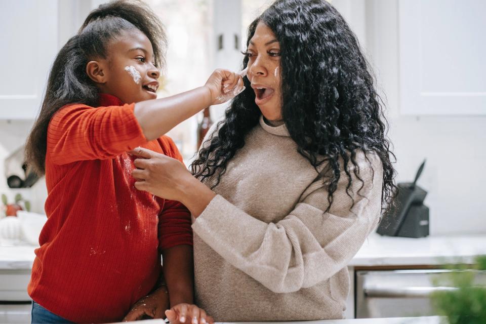 Mom and daughter share a playful moment while baking together.