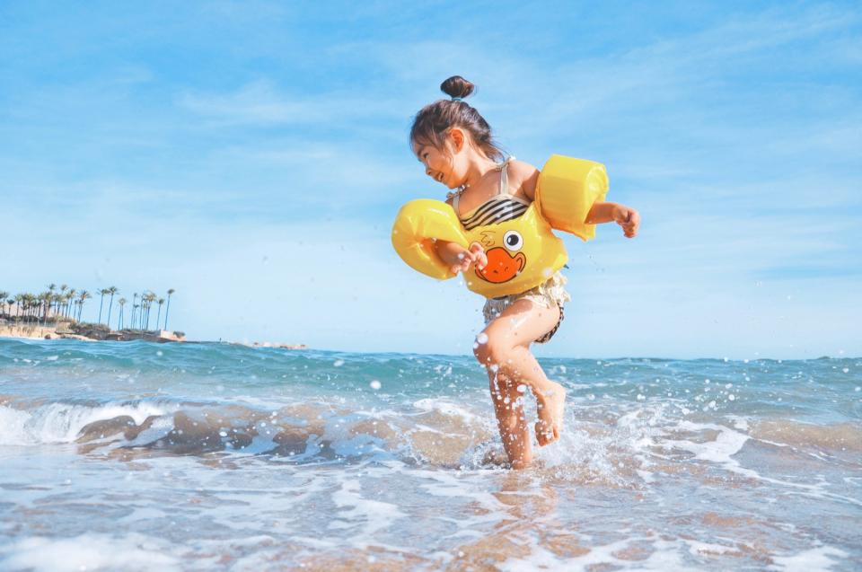 A young girl plays in the water at the beach.