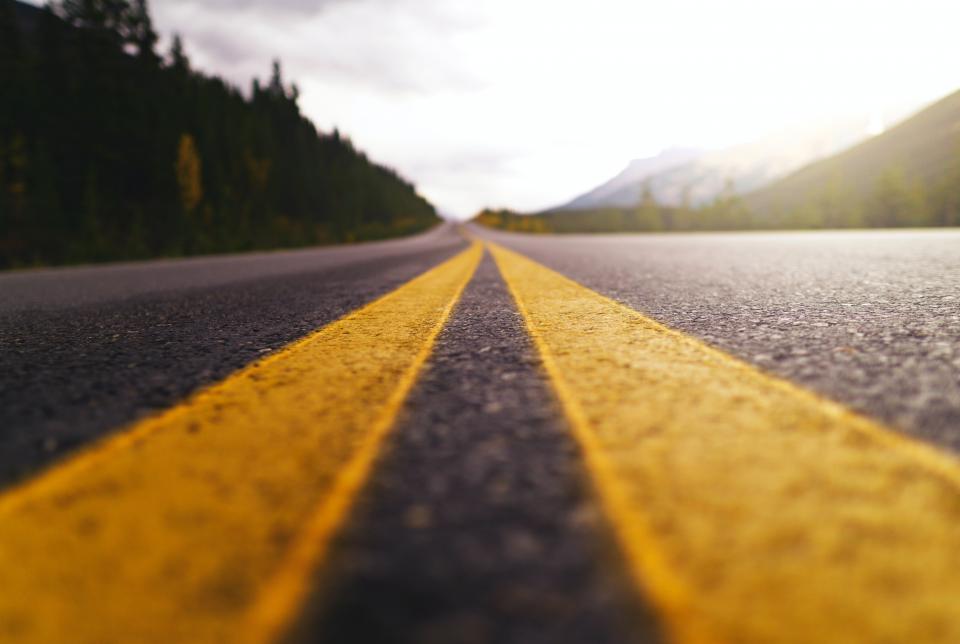 photo of yellow lines on road going into the horizon