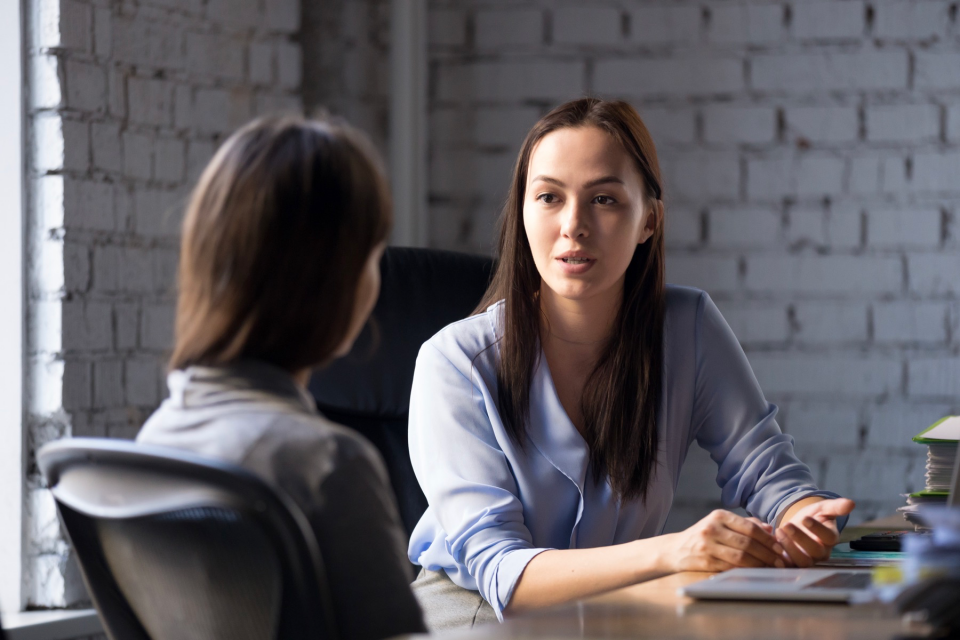 Serious professional female advisor consulting client at meeting