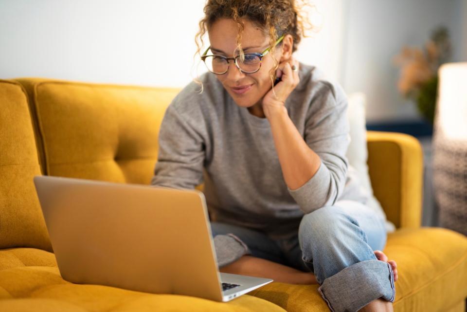 Woman on laptop on couch. 