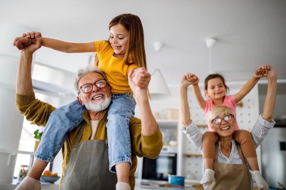 Two happy grandparents playing with their grandchildren.