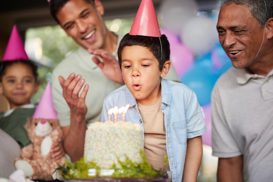 Little boy blowing out birthday candles.