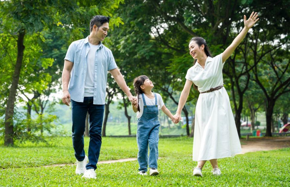 Man and woman with their child in the park. 