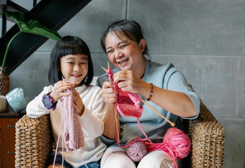Grandma teaching her granddaughter to knit.