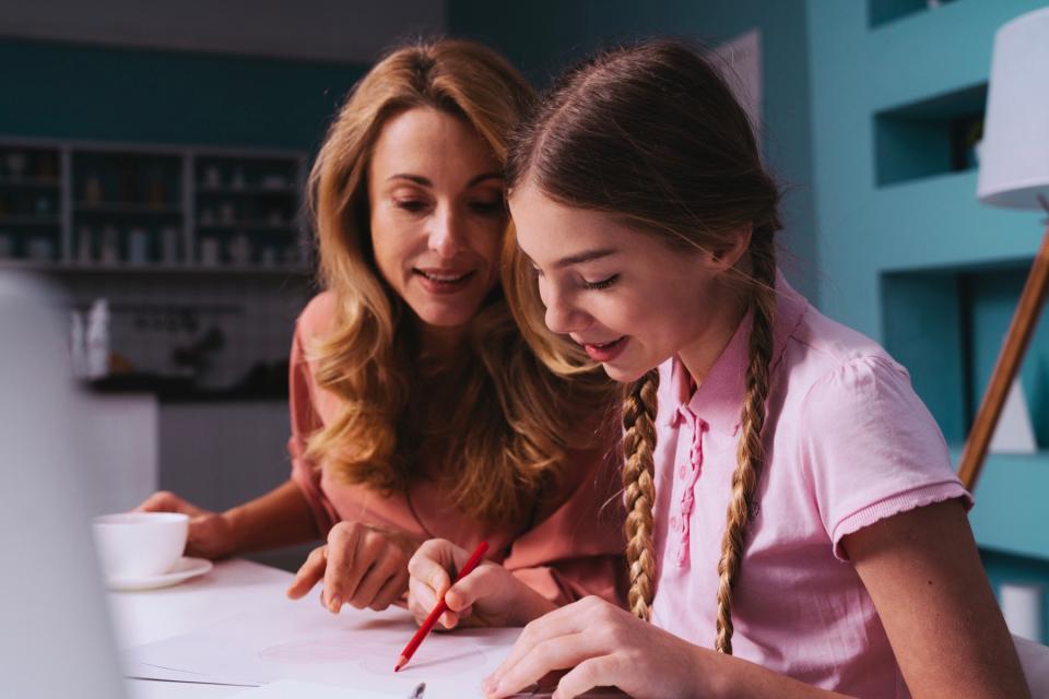 Mom helping teen daughter with homework.