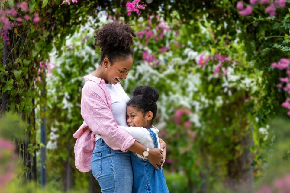 Mom and daughter hugging happily.
