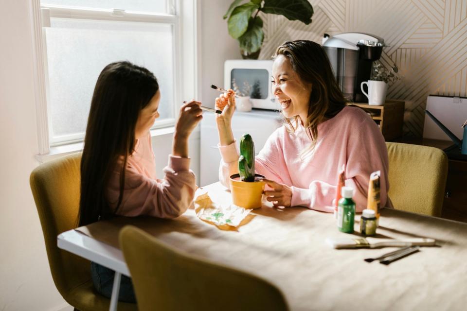 Mom and daughter painting happily.