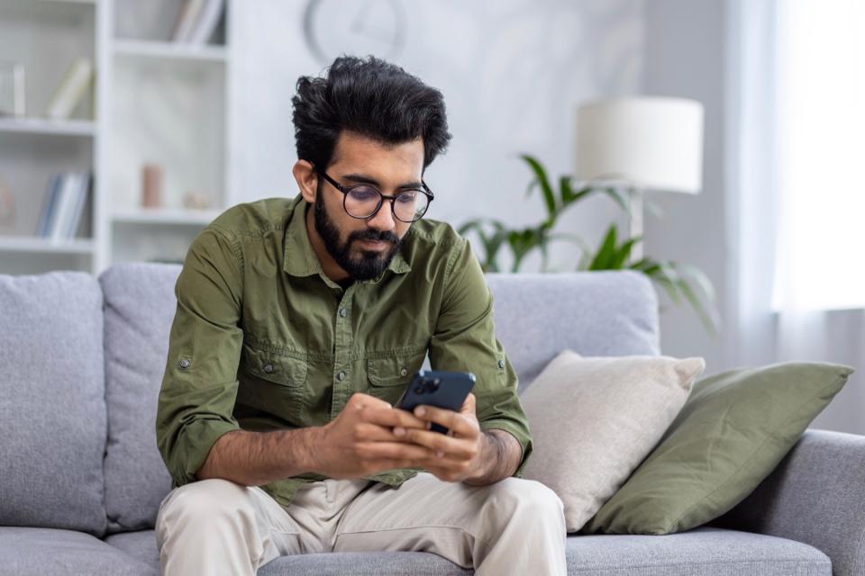 Man on phone while sitting on couch.