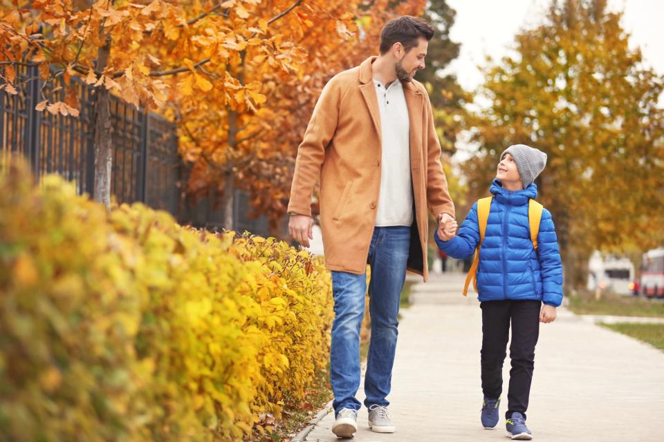Dad and son walking home from school pickup.